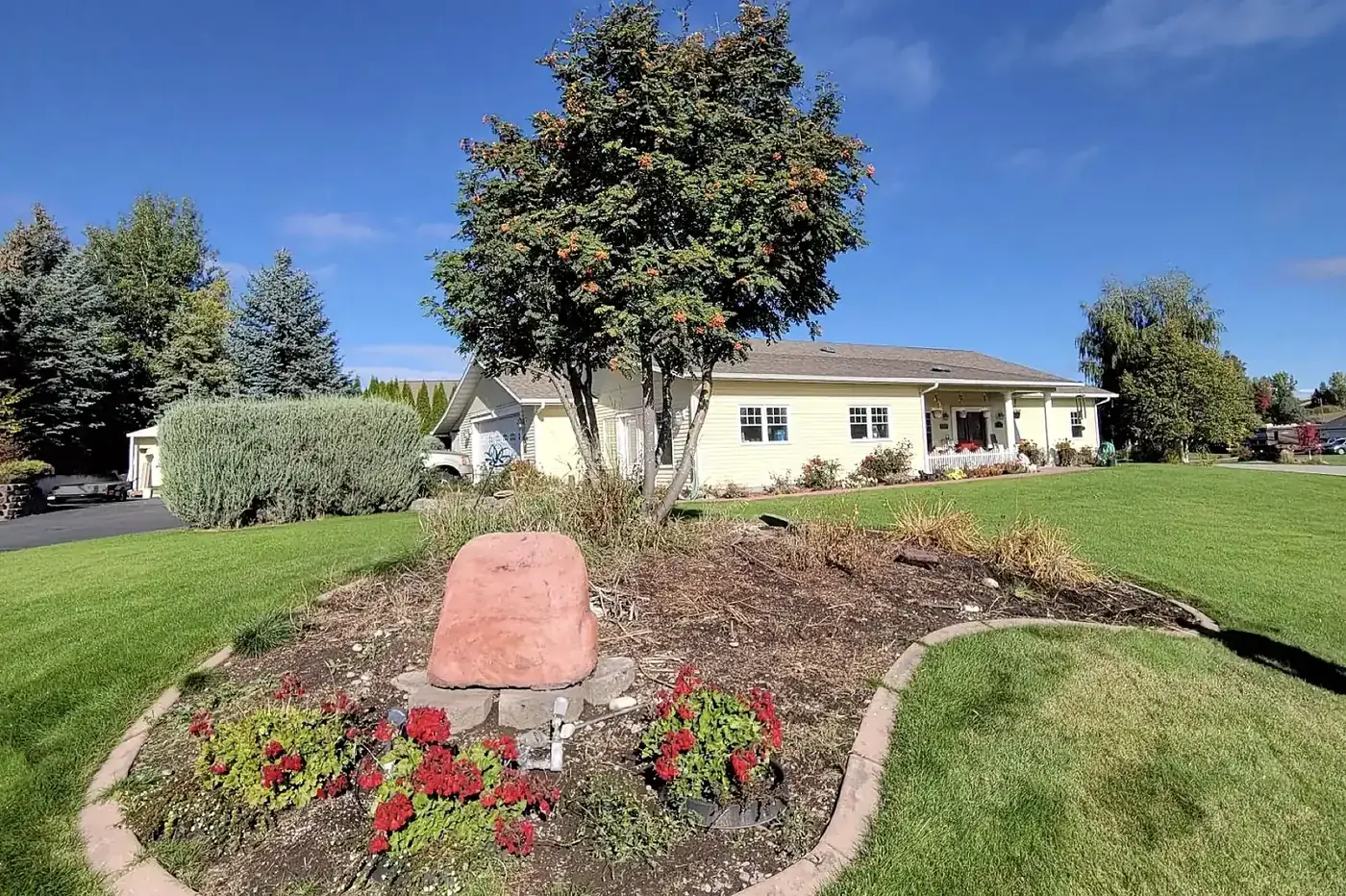 Curved island planting bed with boulder and edging